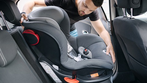 silla de coche de segunda mano- hombre instalando un asiento de seguridad infantil